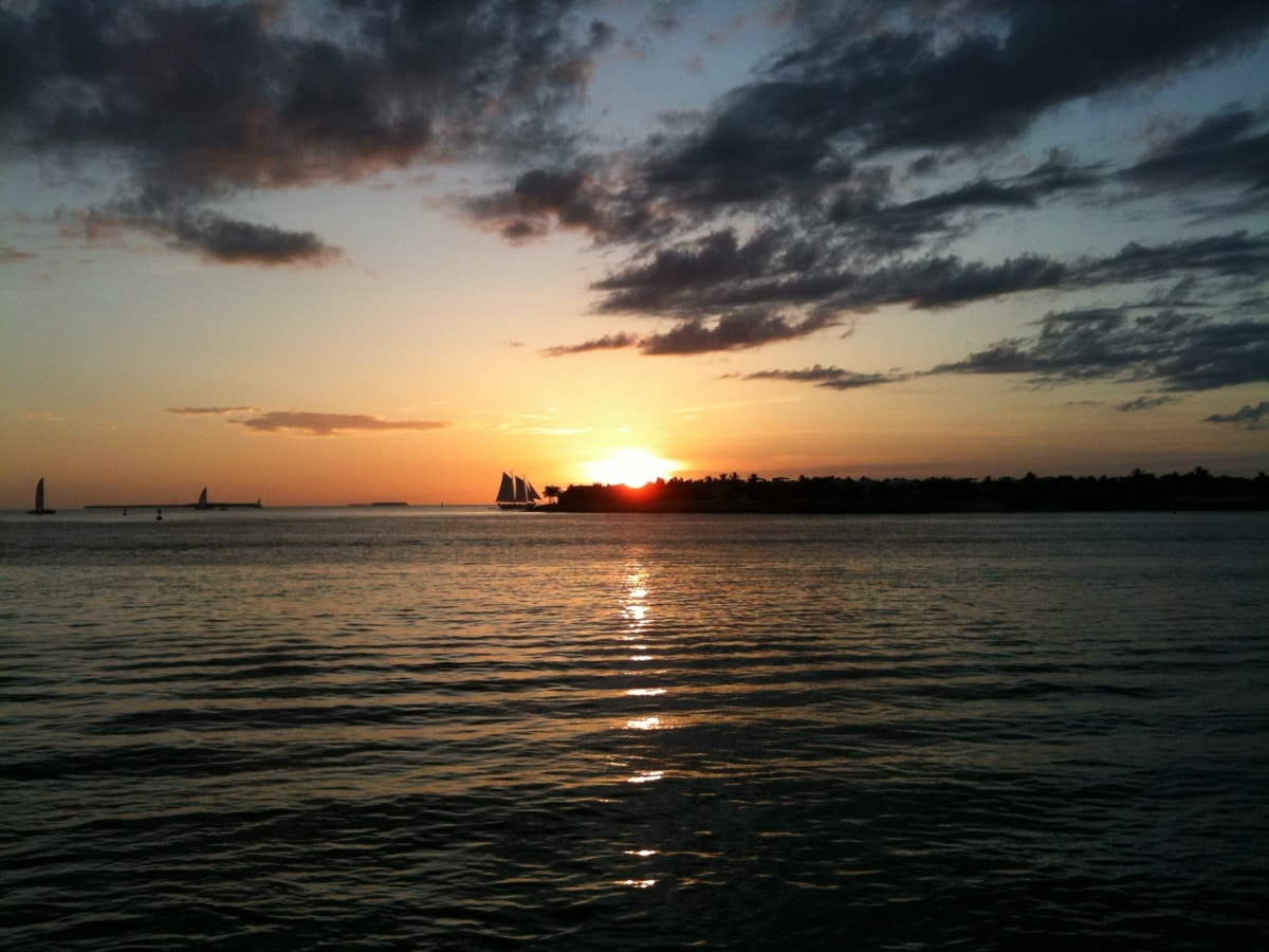 Sunset over the water near Mallory Square in Key West with a schooner on the horizon