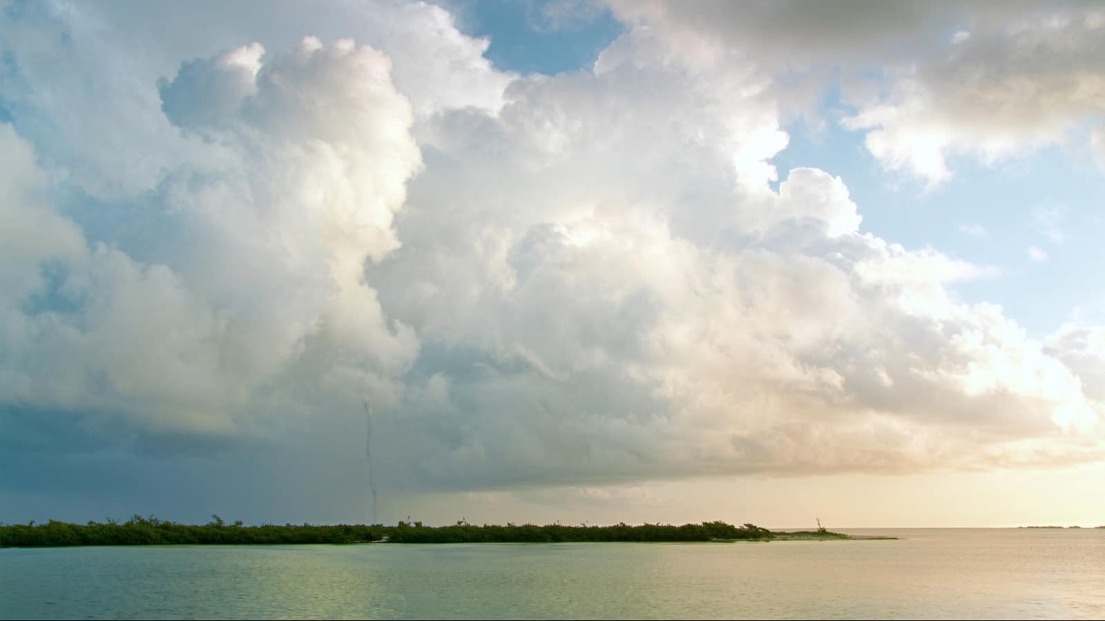 Afternoon thunderclouds building over calm water in the Florida Keys, typical of Key West weather in September